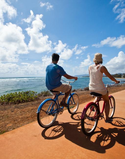 A couple riding bikes in Kapaa Town, Kauai