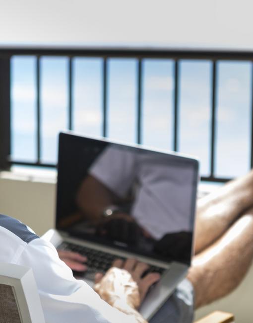 A man working on his computer with an ocean view