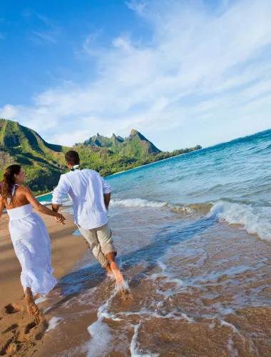 Couple running hand-in-hand on the beach