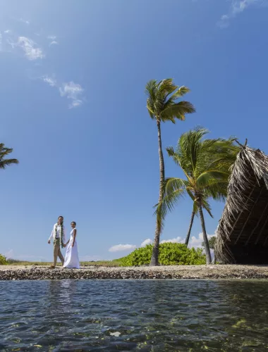 Bride and groom walking on the beach