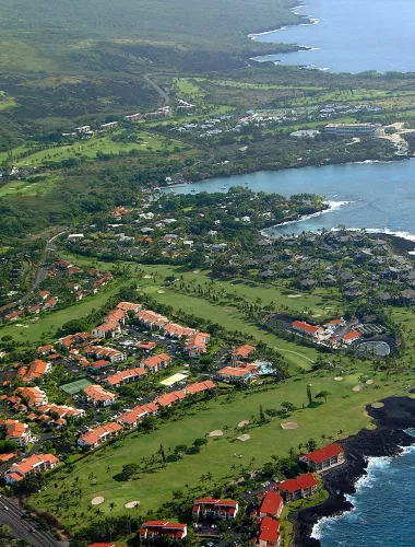 Keauhou Aerial view of the Keauhou resort area, featuring lush green golf courses, homes, and the Pacific Ocean.