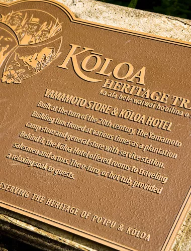 Close-up of a bronze plaque marking the Koloa Heritage Trail.