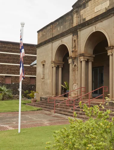 Exterior view of Kauai Museum with historical architecture and a small garden.