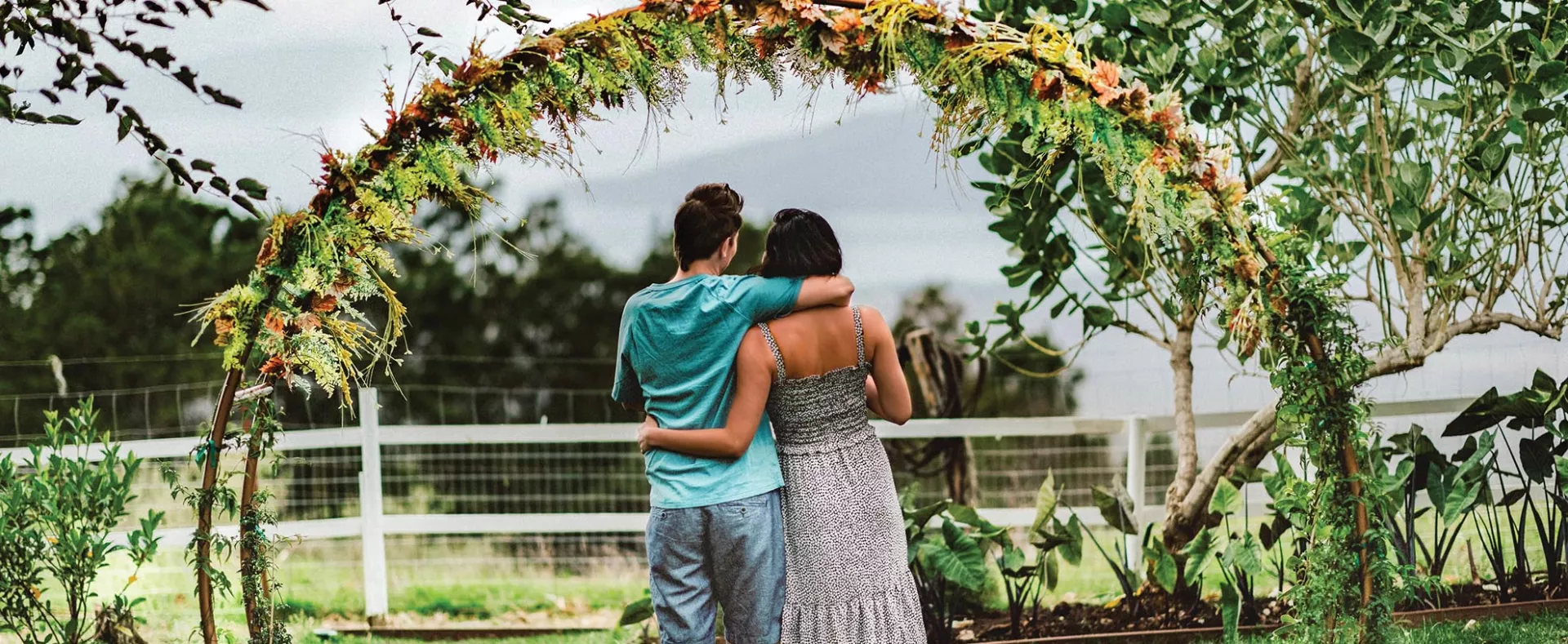 Lesbian couple under flora arch Hawaiian Islands