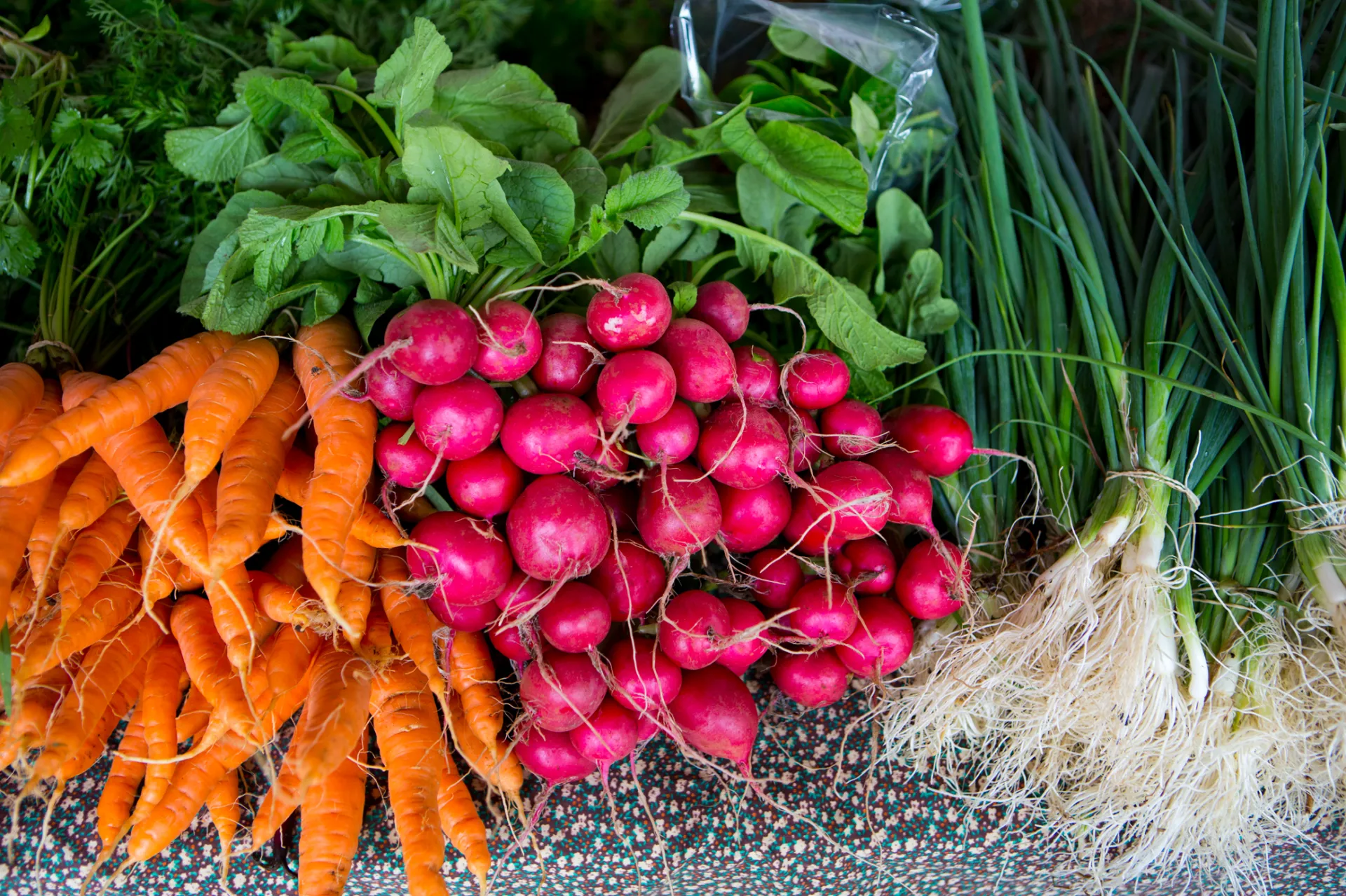 Various fresh, local produce for sale at a farmer's market table