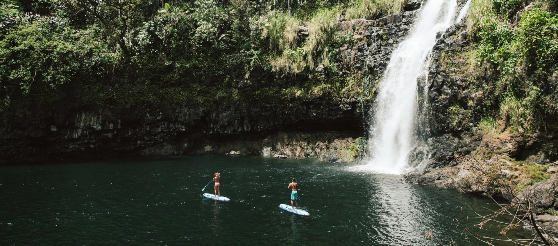Couple paddleboards below Kulaniapia Falls Couple paddleboards below Kulaniapia Falls