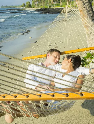 Romantic honeymoon couple in a hammock on the beach on Lanai