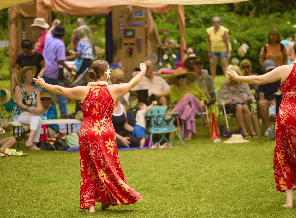 Festival goers enjoy a hula performance on the lawn of Kilauea Lodge
