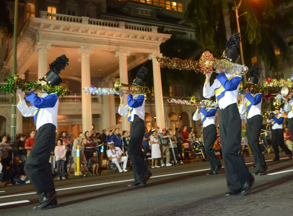 Bands march down torch-lit Kalakaua Avenue.