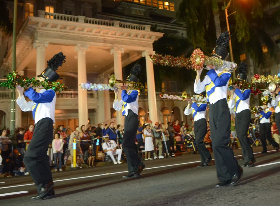 Bands march down torch-lit Kalakaua Avenue.