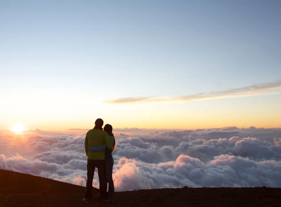 Couple watching the sun rise at Haleakalā National Park on Maui in Hawaiʻi
