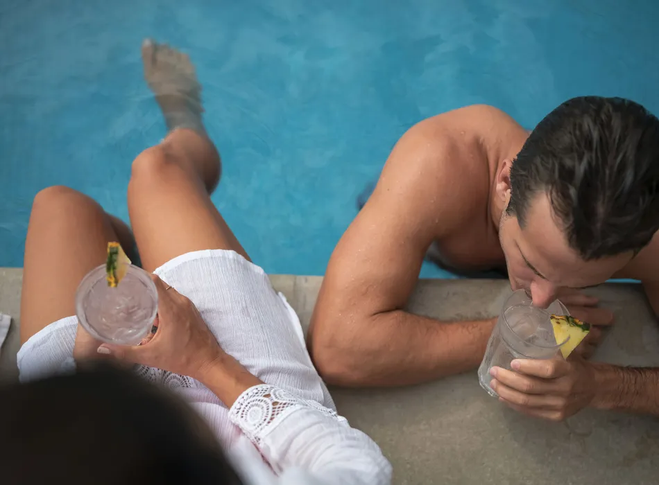 Couple lounging at the pool at the Queen Kapiolani Hotel on Oʻahu in Hawaiʻi
