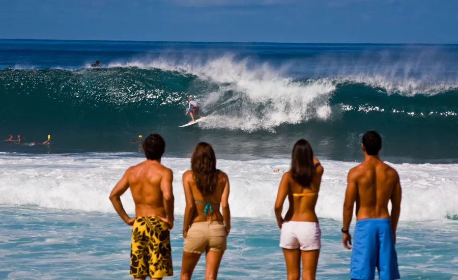 Couples enjoying big wave surfers on Oahu's North Shore